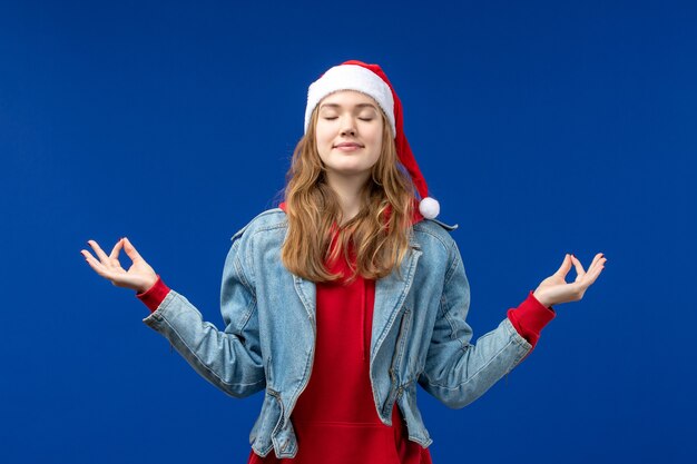 Front view young female meditating on blue background emotion christmas holiday color