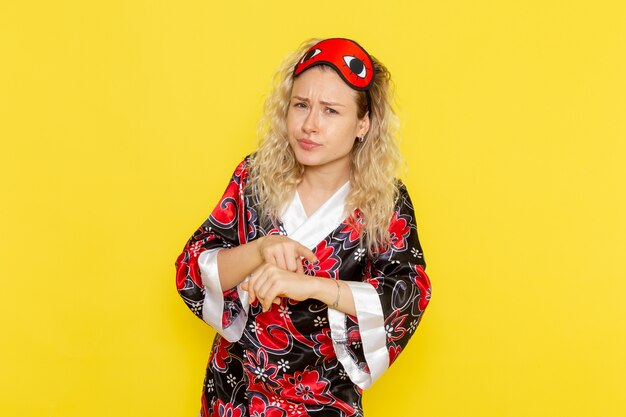 Front view young female in night robe and wearing eye mask preparing to sleep on yellow desk girl night sleep female darkness color