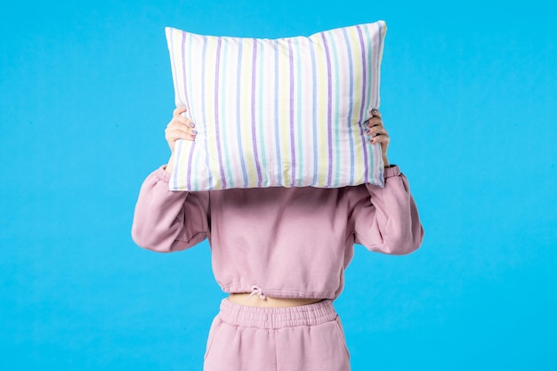 Free photo front view young female in pink pajamas holding pillow on blue wall night color bed rest dream woman sleep insomnia