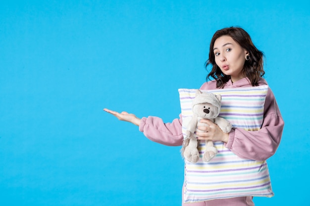 Free photo front view young female in pink pajamas with little toy bear and pillow on blue woman bed night insomnia dream party rest sleep
