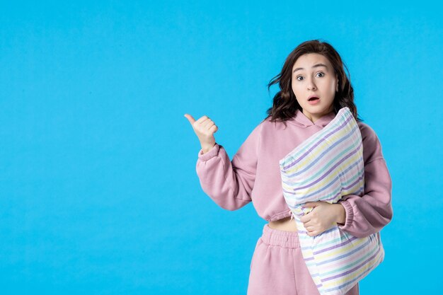 Front view young female in pink pajamas with pillow on bluenight color party bed dream woman sleep insomnia