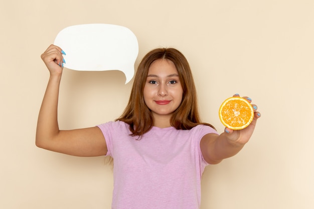 Front view young female in pink t-shirt and blue jeans holding orange and white