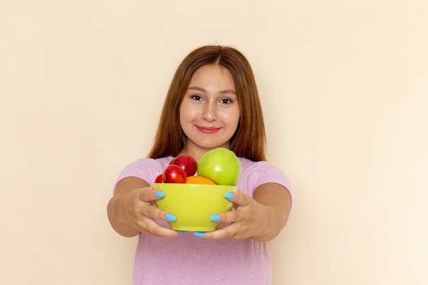 분홍색 티셔츠와 청바지 과일 접시를 들고 전면보기 젊은 여성