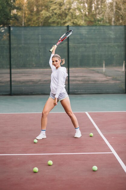 Вид спереди молодая самка играет в теннис