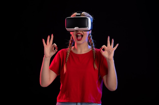 Front view of young female playing virtual reality on dark  game ultrasound fantasy