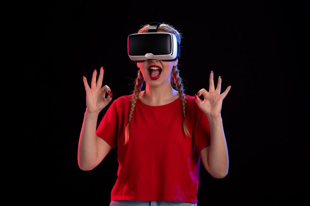 Front view of young female playing virtual reality on dark  game ultrasound fantasy