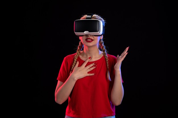 Front view of young female playing virtual reality on dark  visual