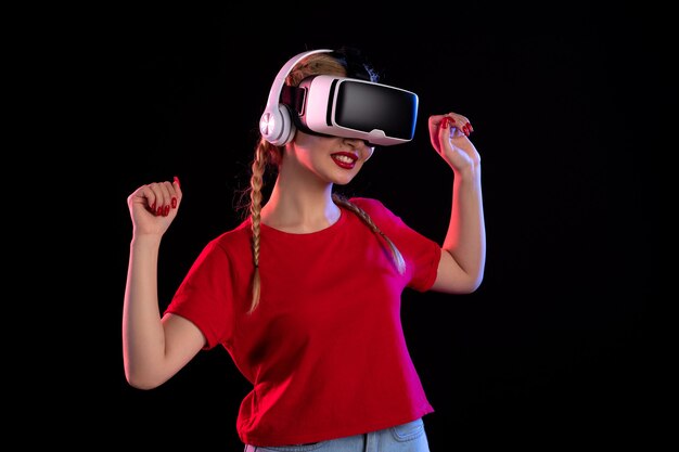 Free photo front view of young female playing vr in headphones on a dark wall