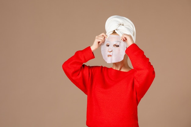 Free photo front view young female preparing to apply face mask on pink background