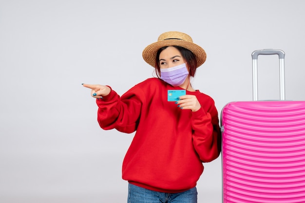 Front view young female preparing for trip in mask on a white wall