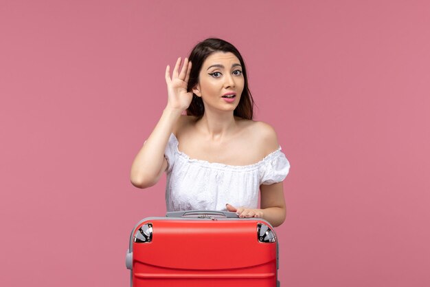 Front view young female preparing for vacation and listening on pink background abroad sea journey voyage travel trip