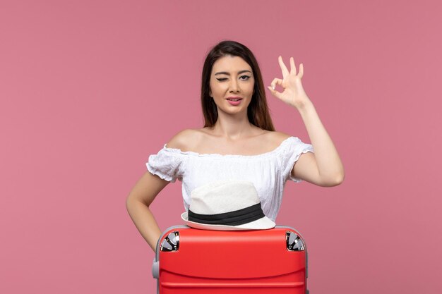 Front view young female preparing for vacation on the pink background journey travelling trip abroad sea voyage