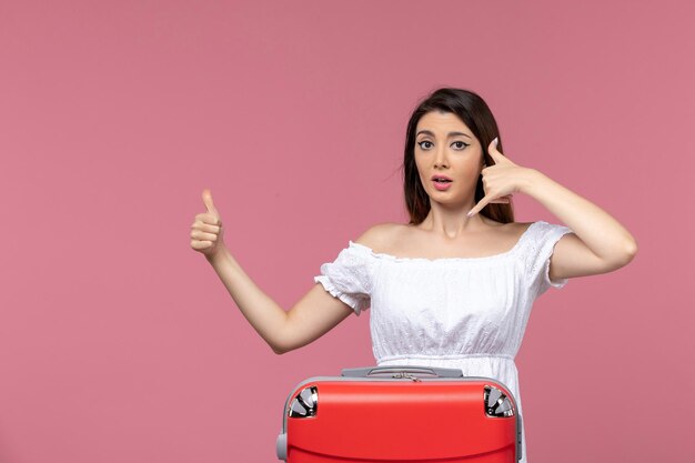 Front view young female preparing for vacation on pink desk vacation abroad travel trip voyage