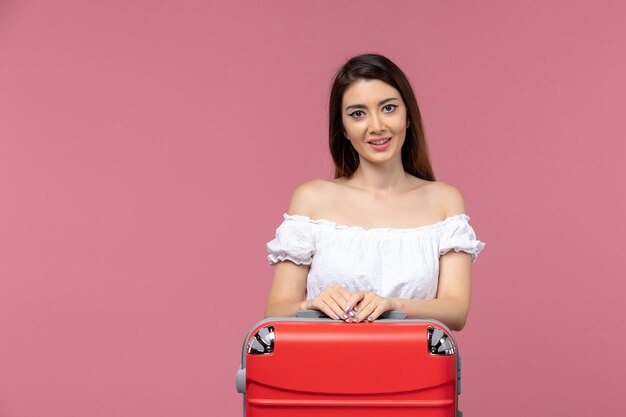 Front view young female preparing for vacation smiling on pink background trip travel voyage vacation woman abroad