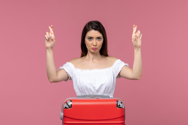 Front view young female preparing for vacation with her bag crossing fingers on pink background journey abroad sea voyage travel trip