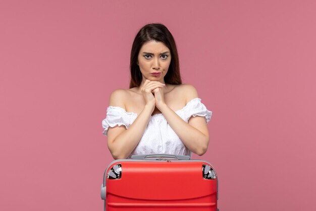 Front view young female preparing for vacation with her bag on pink desk abroad sea journey voyage travel trip