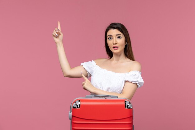 Front view young female preparing for vacation with her red bag on pink background journey travelling abroad voyage trip