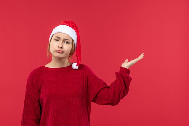 赤い帽子のクリスマス気分、赤い休日のクリスマスの正面図若い女性
