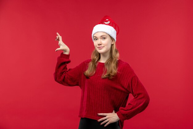 Vista frontale giovane donna con berretto rosso che mostra taglia, donna vacanza rossa