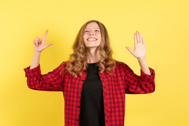 Front view young female in red checkered shirt feeling happy on yellow background woman human emotion model fashion girl