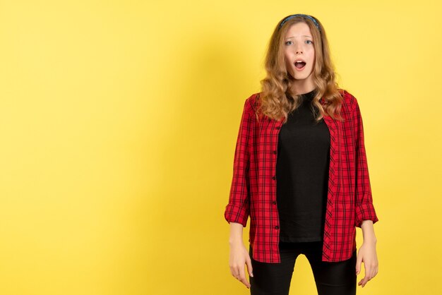 Front view young female in red checkered shirt posing with sad expression on yellow background human emotion color model woman