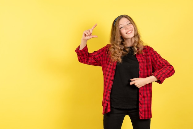Front view young female in red checkered shirt posing with smile on yellow background human girl emotion color model woman
