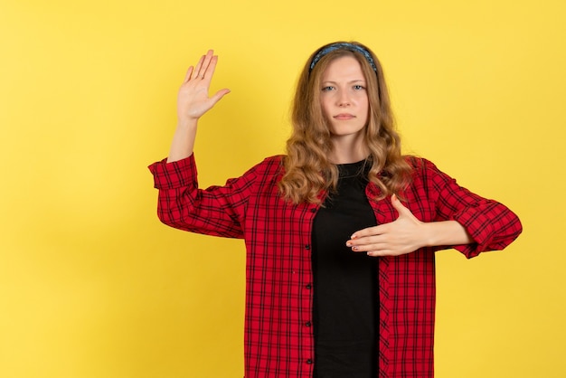 Front view young female in red checkered shirt standing and posing on a yellow background girl color woman model human