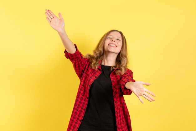 Front view young female in red checkered shirt welcoming someone on yellow background woman human emotion model fashion girl