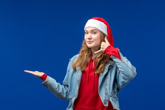 Front view young female in red christmas cap on light blue background christmas emotion color