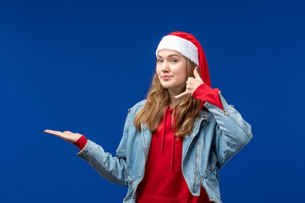 正面図水色の背景に赤いクリスマスキャップの若い女性クリスマス感情色