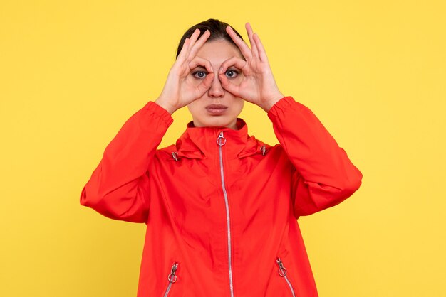 Front view young female in red coat on yellow background