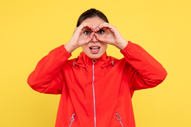 Front view young female in red coat on yellow background