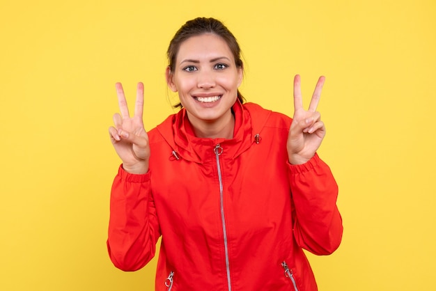 Front view young female in red coat on yellow background