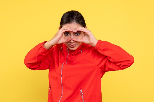 Front view young female in red coat on yellow background