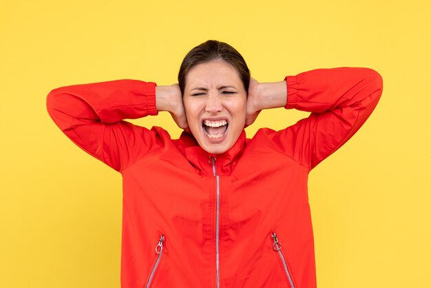 Front view young female in red coat on yellow background