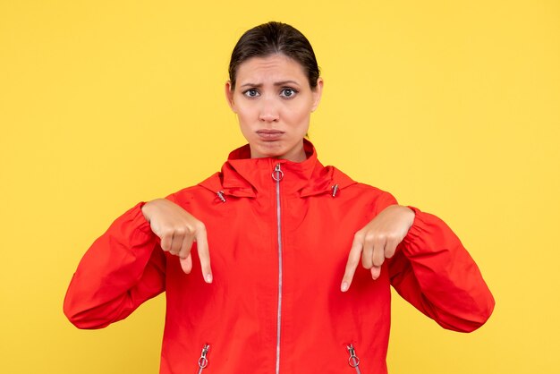 Front view young female in red coat on yellow background