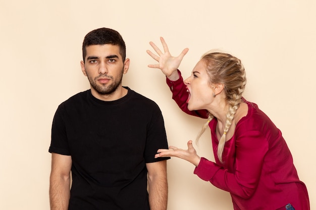 Free photo front view young female in red shirt quarelling with male on the cream space female cloth  photo violence