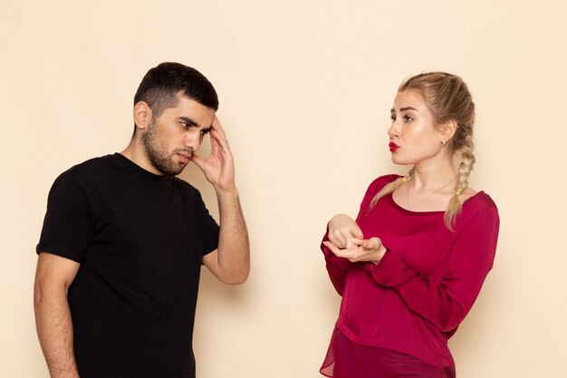 Front view young female in red shirt quarelling with young man on the cream space female cloth  confrontation