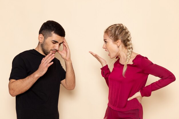 Front view young female in red shirt quarelling with young man on the light space female cloth  photo