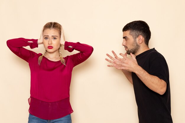 Foto gratuita vista frontale la giovane femmina in camicia rossa soffre di violenza verbale sulla foto di stoffa femminile dello spazio crema