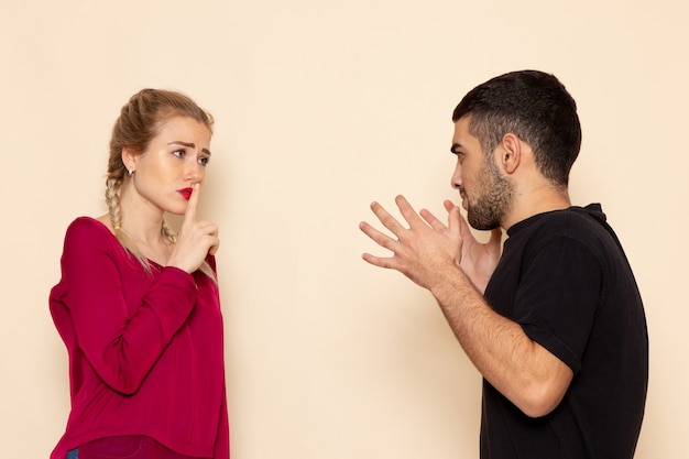 Front view young female in red shirt suffers from verbal violence on the cream space female cloth 