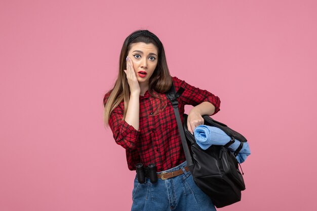 ピンクの机の上のバッグと赤いシャツの正面図若い女性女性写真モデル