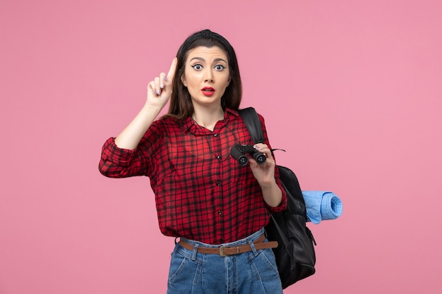 Front view young female in red shirt with binoculars on pink desk woman color student