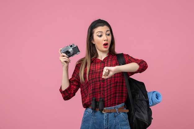Front view young female in red shirt with camera on pink background woman model photo