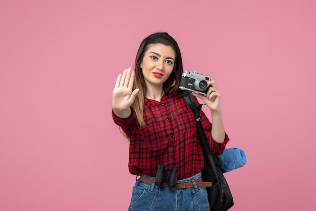 Front view young female in red shirt with camera on pink desk photo woman model