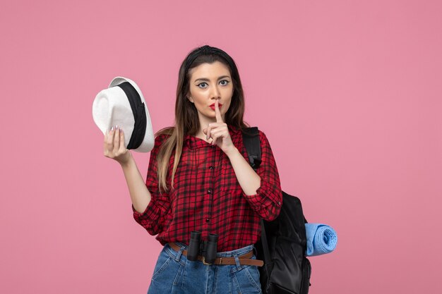 Front view young female in red shirt with hat on pink desk human color woman