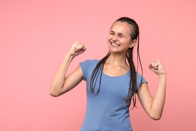 Front view of young female rejoicing on pink