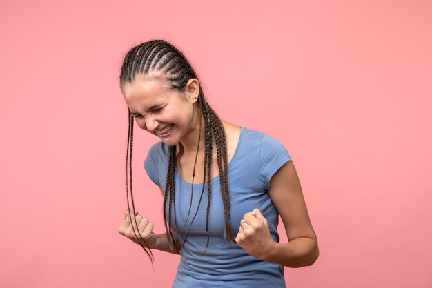 Front view of young female rejoicing on pink