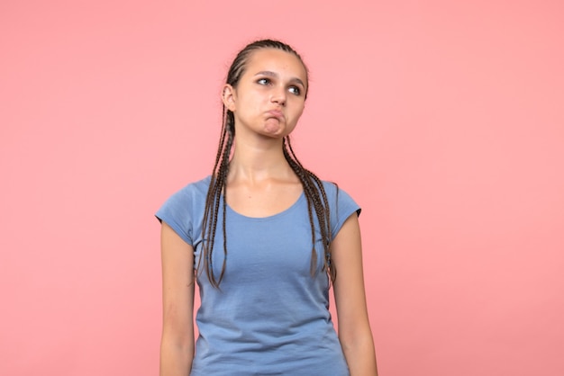 Front view of young female sad on pink