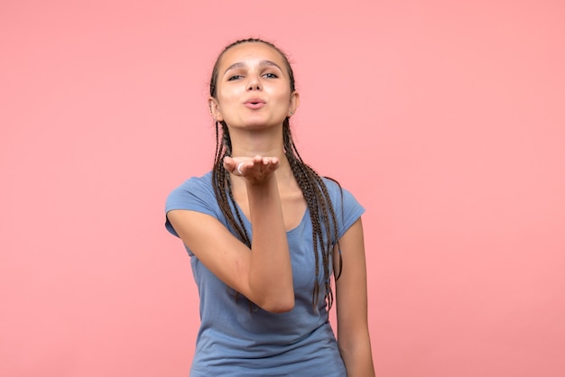 Front view of young female sending air kisses on pink